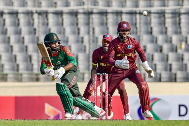 Bangladesh's Towhid Hridoy (L) watches the ball after playing a shot as West Indies' captain and wicketkeeper Shai Hope reacts during the first one-day international (ODI) cricket match between Bangladesh and West Indies at the Sher-e-Bangla National Cricket Stadium in Dhaka on October 18, 2025. (Photo by Munir UZ ZAMAN / AFP)