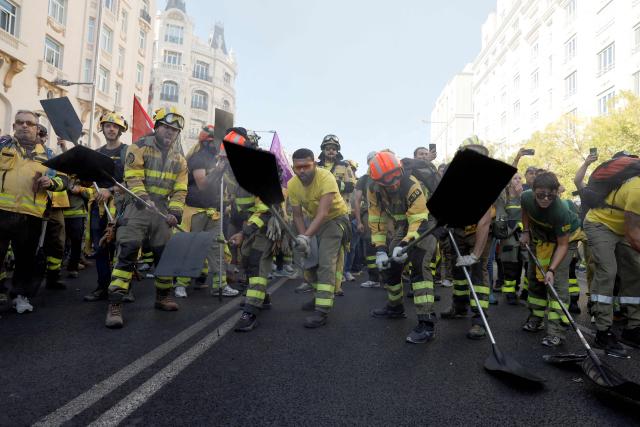 Spanish firefighters tap their shovels as they take part in a protest demanding for more resources in Madrid on October 18, 2025. (Photo by Oscar DEL POZO / AFP)