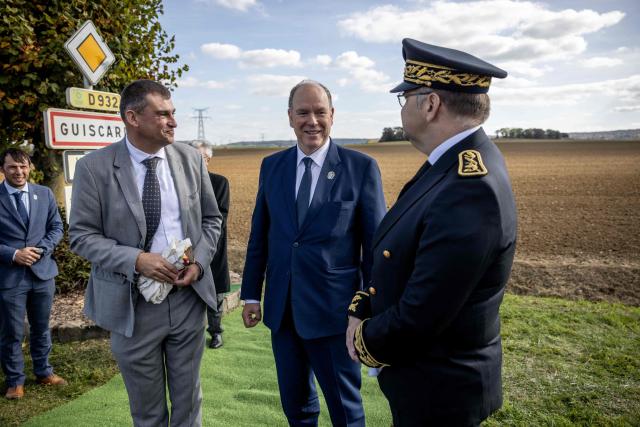 Prince Albert II of Monaco (C) speaks with Guiscard mayor Thibault Delavenne (L) and Compiegne's subprefect Christian Guyard (R) after unveiling a plaque marking the city's as member of the Grimaldi Monaco historical sites, in Guiscard on October 18, 2025. (Photo by Guillaume BAPTISTE / AFP)