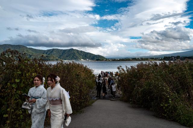 Tourists visit Oishi park in the town of Fujikawaguchiko, Yamanashi prefecture on October 18, 2025. (Photo by Philip FONG / AFP)