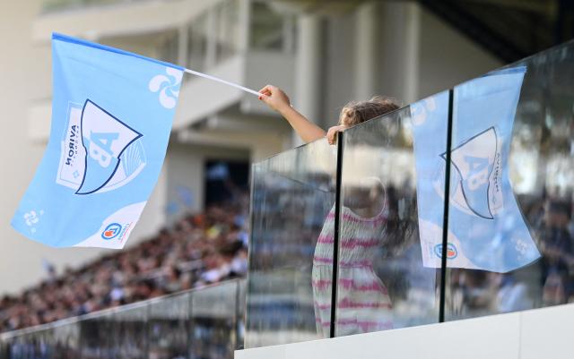 A Bayonne supporter holds a team flag during the French Top14 rugby union match between Aviron Bayonnais (Bayonne) and ASM Clermont Auvergne at Stade Jean Dauger in Bayonne, south-western France on October 18, 2025. (Photo by Gaizka IROZ / AFP)