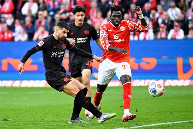 Bayer Leverkusen's French forward #11 Martin Terrier (L) shoots to score the 2-4 goal during the German first division Bundesliga football match Mainz 05 v Bayer 04 Leverkusen in Mainz, western Germany on October 18, 2025. (Photo by Kirill KUDRYAVTSEV / AFP)