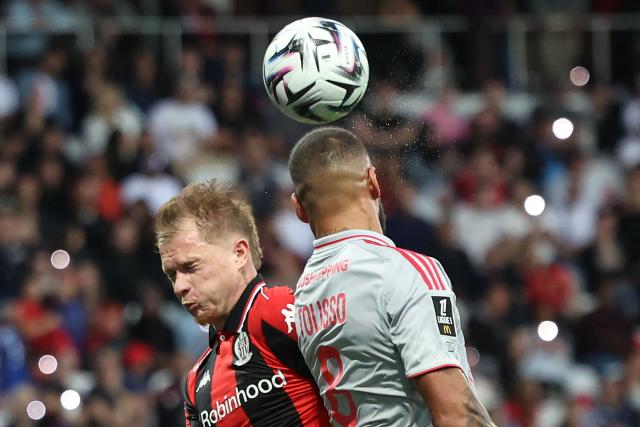 Nice's French defender #26 Melvin Bard (2ndR) and Lyon's French midfielder #08 Corentin Tolisso (R) fight fo the ball during the French L1 football match between OGC Nice and Olympique Lyonnais at the Allianz Riviera Stadium in Nice, south-eastern France on October 18, 2025. (Photo by Valery HACHE / AFP)