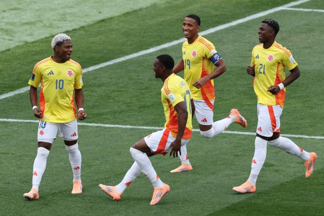 Colombia's forward #10 Oscar Perea celebrates with teammates after scoring the team's first goal during the 2025 FIFA U-20 World Cup third place football match between Colombia and France at the National Stadium in Santiago on October 18, 2025. (Photo by Javier TORRES / AFP)