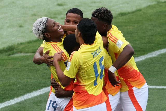 Colombia's forward #10 Oscar Perea celebrates with teammates after scoring the team's first goal during the 2025 FIFA U-20 World Cup third place football match between Colombia and France at the National Stadium in Santiago on October 18, 2025. (Photo by Javier TORRES / AFP)