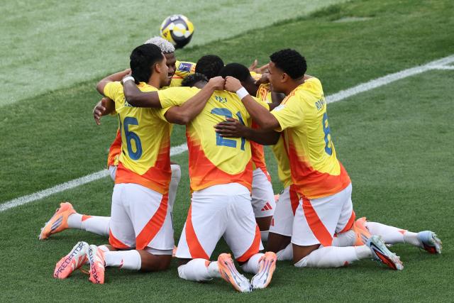 Colombia's forward #10 Oscar Perea celebrates with teammates after scoring the team's first goal during the 2025 FIFA U-20 World Cup third place football match between Colombia and France at the National Stadium in Santiago on October 18, 2025. (Photo by Javier TORRES / AFP)