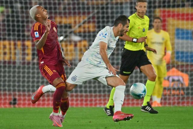 Inter Milan's Armenian forward #22 Henrikh Mkhitaryan fights for the ball with Roma's Brazilian defender #43 Wesley during the Italian Serie A football match between AS Roma and Inter Milan at the Olympic Stadium in Rome on October 18, 2025. (Photo by Filippo MONTEFORTE / AFP)