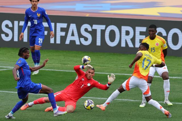 France's midfielder #19 Fode Sylla fights for the ball with Colombia's goalkeeper #01 Jordan Garcia, and Colombia's midfielder #17 Juan Arizala during the 2025 FIFA U-20 World Cup third place football match between Colombia and France at the National Stadium in Santiago on October 18, 2025. (Photo by Javier TORRES / AFP)