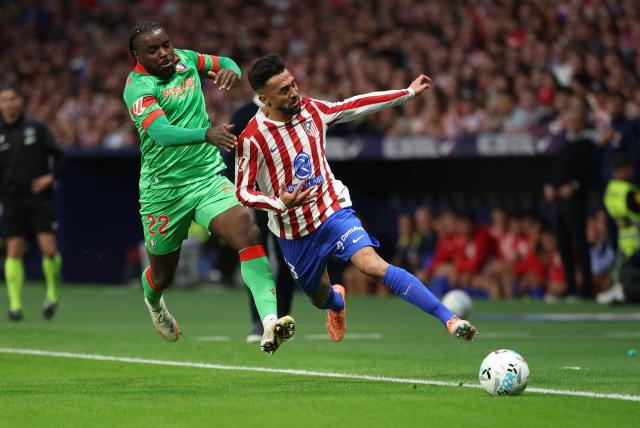 Osasuna's Cameroonian defender #22 Flavien Boyomo (L) and Atletico Madrid's Argentine midfielder #23 Nico Gonzalez fight for the ball during the Spanish league football match between Club Atletico de Madrid and CA Osasuna at Metropolitano Stadium in Madrid on October 18, 2025. (Photo by Thomas COEX / AFP)