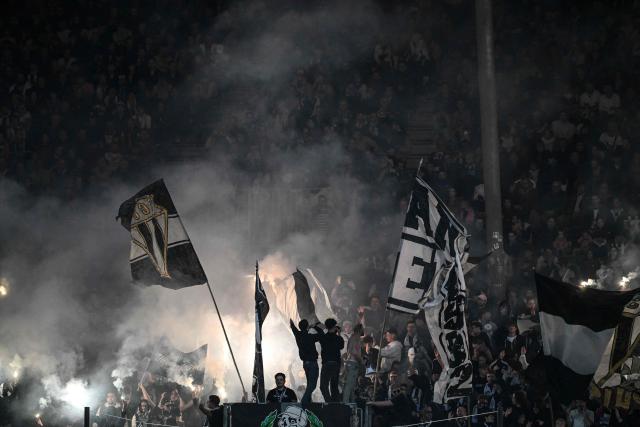 Angers' supporters wave flags and cheer their team  during the French L1 football match between SCO Angers and AS Monaco at the Stade Raymond-Kopa in Angers on October 18, 2025. (Photo by Sebastien Salom-Gomis / AFP)