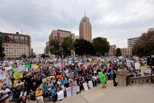 Protesters rally during the "No Kings" national day of protest in Landing, Michigan, on October 18, 2025. From New York to San Francisco, millions of Americans are expected to hit the streets to voice their anger over President Donald Trump's policies at nationwide "No Kings" protests. (Photo by JEFF KOWALSKY / AFP)