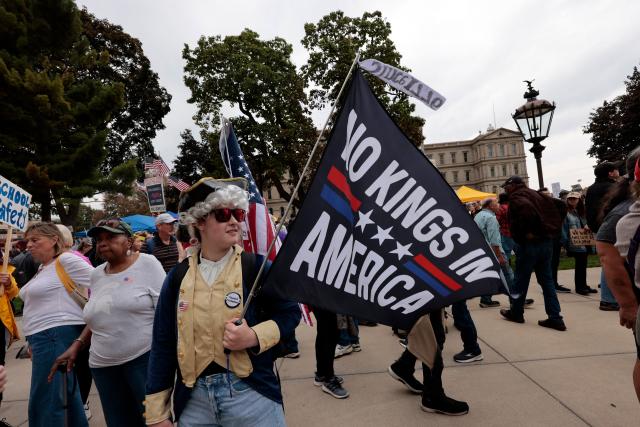 Protesters rally during the "No Kings" national day of protest in Landing, Michigan, on October 18, 2025. From New York to San Francisco, millions of Americans are expected to hit the streets to voice their anger over President Donald Trump's policies at nationwide "No Kings" protests. (Photo by JEFF KOWALSKY / AFP)