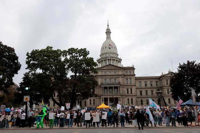 Protesters rally during the "No Kings" national day of protest in Landing, Michigan, on October 18, 2025. From New York to San Francisco, millions of Americans are expected to hit the streets to voice their anger over President Donald Trump's policies at nationwide "No Kings" protests. (Photo by JEFF KOWALSKY / AFP)