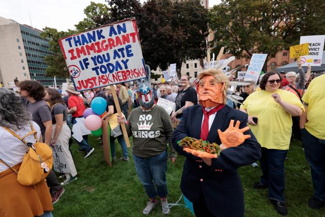 Protesters rally during the "No Kings" national day of protest in Landing, Michigan, on October 18, 2025. From New York to San Francisco, millions of Americans are expected to hit the streets to voice their anger over President Donald Trump's policies at nationwide "No Kings" protests. (Photo by JEFF KOWALSKY / AFP)