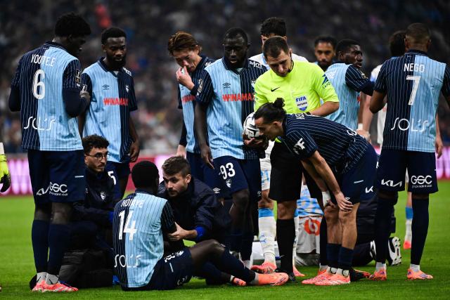 Le Havre's Senegalese midfielder #14 Rassoul Ndiaye is checked by medical staff after a contact with another player during the French L1 football match between Olympique de Marseille (OM) and Le Havre AC at the Stade Velodrome in Marseille, southern France, on October 18, 2025. (Photo by Miguel MEDINA / AFP)
