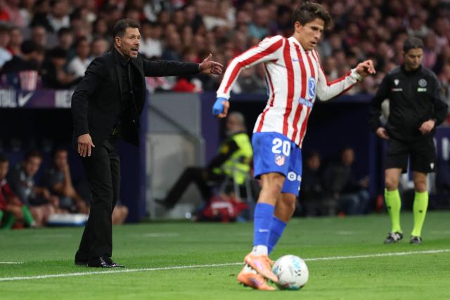 Atletico Madrid's Argentine coach Diego Simeone reacts as his son Atletico Madrid's Argentine forward #20 Giuliano Simeone controls the ball during the Spanish league football match between Club Atletico de Madrid and CA Osasuna at Metropolitano Stadium in Madrid on October 18, 2025. (Photo by Thomas COEX / AFP)