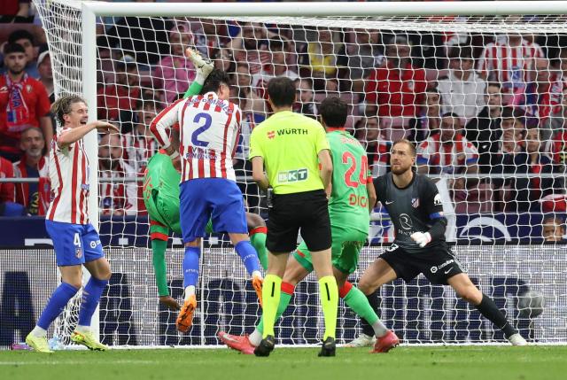 Osasuna's Cameroonian defender #22 Flavien Boyomo (2L) kicks Atletico Madrid's Uruguayan defender #02 Jose Gimenez's head during the Spanish league football match between Club Atletico de Madrid and CA Osasuna at Metropolitano Stadium in Madrid on October 18, 2025. (Photo by Thomas COEX / AFP)