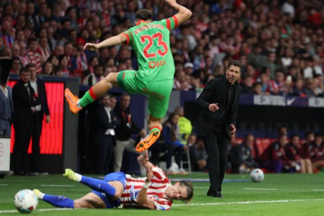 Atletico Madrid's Argentine coach Diego Simeone looks at Osasuna's Spanish defender #23 Abel Bretones jumping over Atletico Madrid's English midfielder #04 Conor Gallagher during the Spanish league football match between Club Atletico de Madrid and CA Osasuna at Metropolitano Stadium in Madrid on October 18, 2025. (Photo by Thomas COEX / AFP)