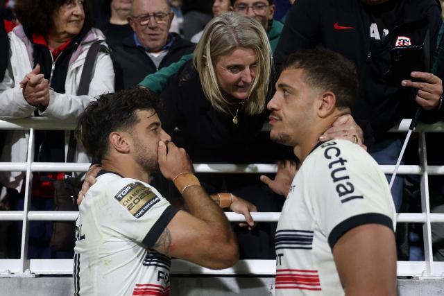 Toulouse's French scrum half Romain Ntamack (L) and Toulouse' French number 8 Theo Ntamack (R) talk with their mother at the end of the French Top14 rugby union match between Section Paloise Bearn Pyrenees (Pau) and Stade Toulousain Rugby (Toulouse) at Stade du Hameau in Pau, south-western France on October 18, 2025. (Photo by ROMAIN PERROCHEAU / AFP)
