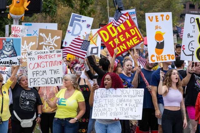 Protesters rally during the "No Kings" national day of protest in Kansas City, Missouri  on October 18, 2025. From New York to San Francisco, millions of Americans are expected to hit the streets to voice their anger over President Donald Trump's policies at nationwide "No Kings" protests. (Photo by Austin Casey Johnson / AFP)