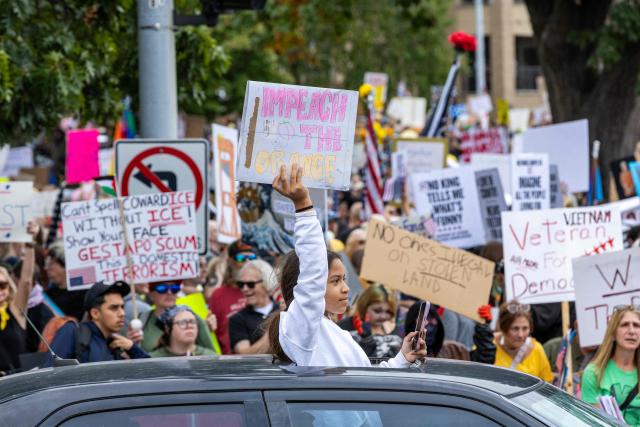 Protesters rally during the "No Kings" national day of protest in Kansas City, Missouri  on October 18, 2025. From New York to San Francisco, millions of Americans are expected to hit the streets to voice their anger over President Donald Trump's policies at nationwide "No Kings" protests. (Photo by Austin Casey Johnson / AFP)