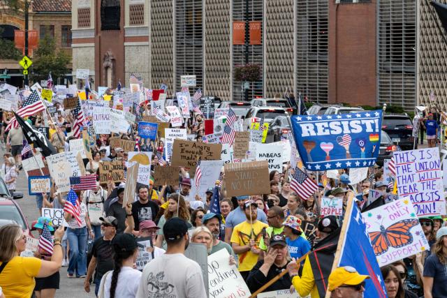 Protesters rally during the "No Kings" national day of protest in Kansas City, Missouri  on October 18, 2025. From New York to San Francisco, millions of Americans are expected to hit the streets to voice their anger over President Donald Trump's policies at nationwide "No Kings" protests. (Photo by Austin Casey Johnson / AFP)
