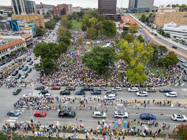 Protesters rally during the "No Kings" national day of protest in Kansas City, Missouri  on October 18, 2025. From New York to San Francisco, millions of Americans are expected to hit the streets to voice their anger over President Donald Trump's policies at nationwide "No Kings" protests. (Photo by Austin Casey Johnson / AFP)