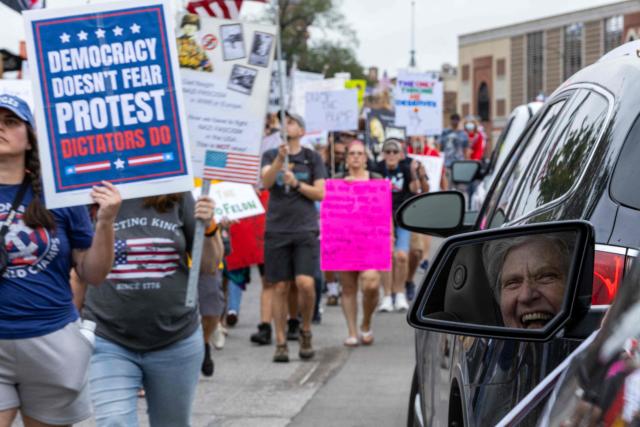 Protesters rally during the "No Kings" national day of protest in Kansas City, Missouri  on October 18, 2025. From New York to San Francisco, millions of Americans are expected to hit the streets to voice their anger over President Donald Trump's policies at nationwide "No Kings" protests. (Photo by Austin Casey Johnson / AFP)