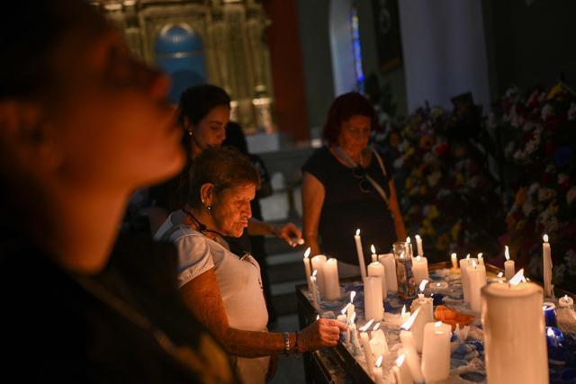 Catholic faithfuls light candles during a mass at the Nuestra Senora de la Candelaria church in Caracas on October 18, 2025. Pope Leo XIV is set to canonize Venezuela’s first saints, Dr. Jose Gregorio Hernandez and Sister Maria del Carmen Rendiles, during a ceremony in St. Peter's Square on October 19, 2025. (Photo by Federico PARRA / AFP)