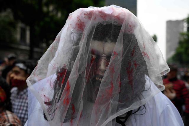 A person attends the annual Zombie Parade ahead of the Day of the Dead in Mexico City on October 18, 2025. (Photo by Alfredo ESTRELLA / AFP)