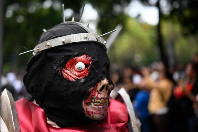 A person attends the annual Zombie Parade ahead of the Day of the Dead in Mexico City on October 18, 2025. (Photo by Alfredo ESTRELLA / AFP)