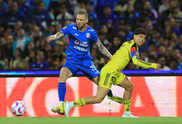Cruz Azul's Argentine forward #29 Rodolfo Rotondi and America's defender #05 Kevin Alvarez fight for the ball during the Liga MX Apertura football tournament match between Cruz Azul and america at the Olimpico Universitario Stadium in Mexico City on October 18, 2025. (Photo by Victor Cruz / AFP)