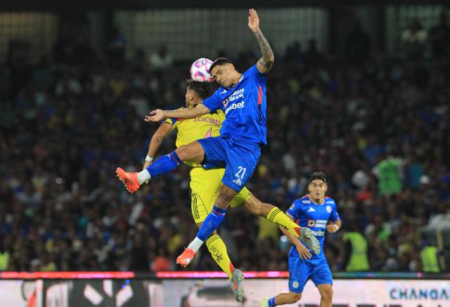Cruz Azul's Uruguayan forward #21 Gabriel Fernandez and America's Uruguayan defender #04 Sebastian Caceres fight for the ball during the Liga MX Apertura football tournament match between Cruz Azul and america at the Olimpico Universitario Stadium in Mexico City on October 18, 2025. (Photo by Victor Cruz / AFP)