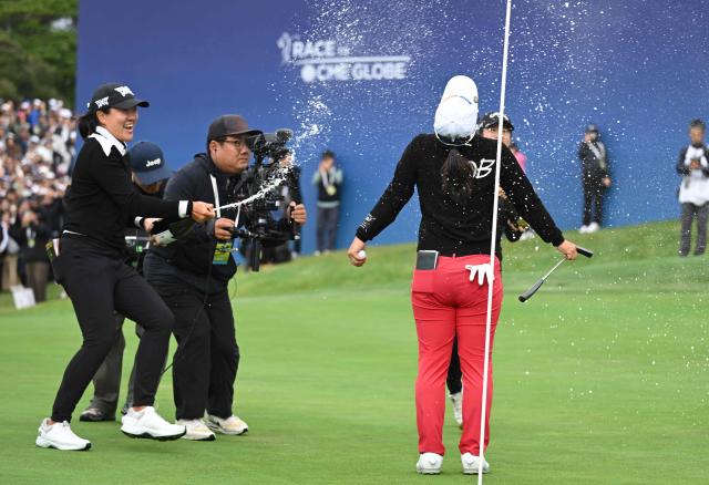 Kim Sei-young of South Korea (R) celebrates her victory at the end of the final round of the LPGA Tour - BMW Ladies Championship golf tournament at Pine Beach Golf Links in Haenam on October 19, 2025. (Photo by Jung Yeon-je / AFP)