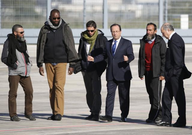 (FILES) French president Francois Hollande (3ndR) flanked by former French hostages (LtoR) Marc Feret, Thierry Dol, Pierre Legrand and Daniel Larribe, and Foreign Minister Laurent Fabius, walks on the tarmac prior to deliver a speech upon the hostages' arrival at the military airport of Villacoublay outside Paris, on October 30, 2013. Four French hostages who were kidnapped by Al-Qaeda in the Islamic Maghreb in northern Niger in 2010 have been released on October 29. Frenchmen , Daniel Larribe,and were working for French nuclear giant Areva when they were kidnapped on September 16, 2010, from a uranium compound in Arlit, north-central Niger. AFP PHOTO / KENZO TRIBOUILLARD. Parisian investigating judges have referred nuclear giant Areva (now Orano) to trial for unintentional injury, suspected of being partly responsible for the 2010 kidnapping of five French citizens by Al-Qaeda near the Arlit uranium mine in Niger, AFP learned from sources close to the case on October 19, 2025. (Photo by Kenzo TRIBOUILLARD / AFP)