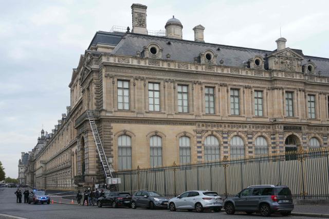 French police officers stand next to a furniture elevator used by robbers to enter the Louvre Museum, on Quai Francois Mitterrand, in Paris on October 19, 2025. Robbers broke in to the Louvre and fled with jewellery on October 19, 2025 morning, a source close to the case said, adding that its value was still being evaluated. A police source said an unknown number of thieves arrived on a scooter armed with small chainsaws and used a goods lift to reach the room they were targeting. (Photo by Dimitar DILKOFF / AFP)