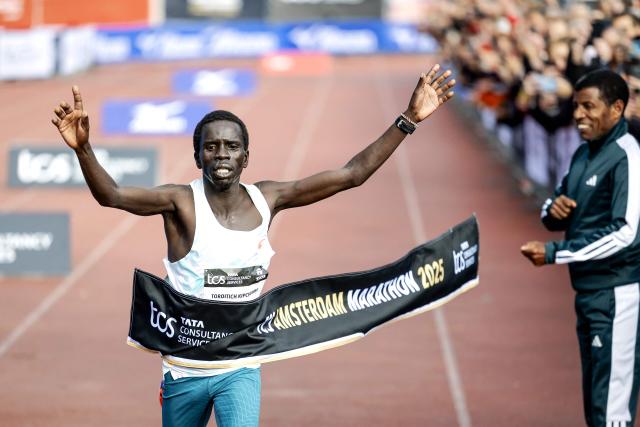Kenya's Geofry Toroitich Kipchumba crosses the finish line next to former Ethiopian athlete Haile Gebrselassie to win the 50th edition of the Amsterdam Marathon in Amsterdam on October 19, 2025. (Photo by Koen van Weel / ANP / AFP) / Netherlands OUT