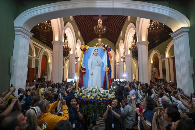 Catholic faithful carry an image of Sister Carmen Rendiles Martinez during her canonization ceremony at the Nuestra Senora de la Candelaria church in Caracas on October 18, 2025. (Photo by Federico PARRA / AFP)
