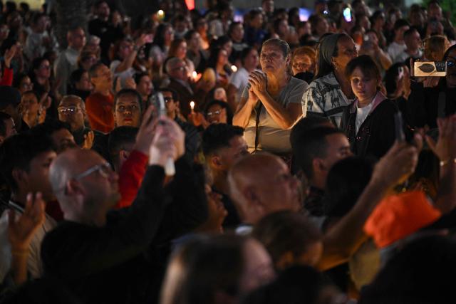 Catholic faithfuls gather at La Candelaria Square to attend the canonization ceremony of Venezuelan doctor Jose Gregorio Hernandez and Venezuelan Sister Maria Rendiles in Caracas on October 19, 2025. (Photo by Federico PARRA / AFP)
