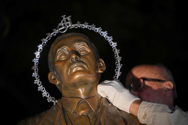 A halo is placed above the head of a statue of Venezuelan docto Jose Gregorio Hernandez during his canonization ceremony at the Nuestra Senora de la Candelaria church in Caracas on October 19, 2025. (Photo by Federico PARRA / AFP)