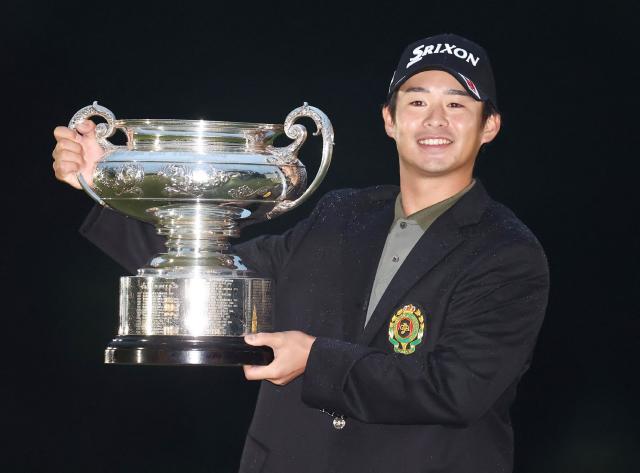 This photo taken on October 19, 2025 shows Naoyuki Kataoka smiling with the trophy after winning the Japan Open golf tournament, his first major title, at Nikko Country Club in Nikko, Tochigi prefecture, north of Tokyo. World number 500 Naoyuki Kataoka will make his major debut next year after winning the Japan Open on October 19. (Photo by JIJI Press / AFP) / Japan OUT