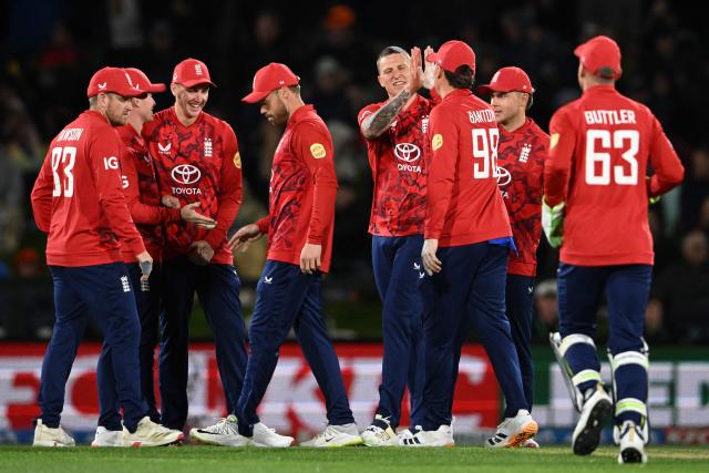 England's Brydon Carse (C) celebrates with teammates after taking the wicket of New Zealand's Tim Robinson during the second Twenty20 international cricket match between New Zealand and England at Hagley Oval in Christchurch on October 20, 2025. (Photo by Sanka VIDANAGAMA / AFP)