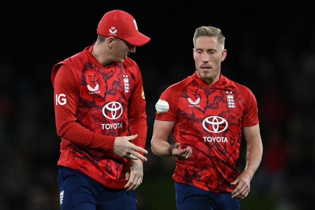 England's Harry Brook (L) passes the ball to Luke Wood during the second Twenty20 international cricket match between New Zealand and England at Hagley Oval in Christchurch on October 20, 2025. (Photo by Sanka VIDANAGAMA / AFP)