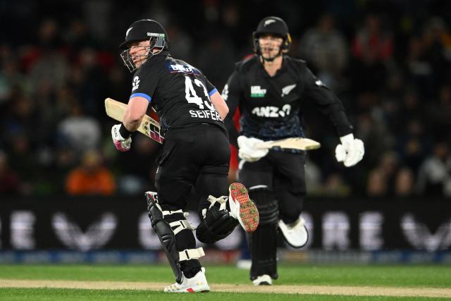 New Zealand's Tim Seifert (L) and Mark Chapman (L) run between the wickets during the second Twenty20 international cricket match between New Zealand and England at Hagley Oval in Christchurch on October 20, 2025. (Photo by Sanka VIDANAGAMA / AFP)