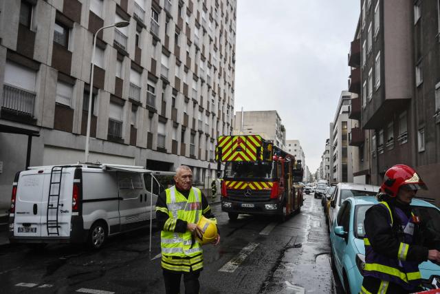 TOPSHOT - Firefighters work at the site following a fire in a residential building in Lyon on October 20, 2025. Four people died on October 20, 2025 in a fire in a ten-story building in Lyon's 3rd arrondissement, which broke out at around 5:10 a.m., according to the Rhône prefecture. The fire was extinguished around 7:00 a.m. Ten other people were examined by emergency services, and a gymnasium was opened by the city of Lyon to accommodate those involved, authorities said. (Photo by JEAN-PHILIPPE KSIAZEK / AFP)
