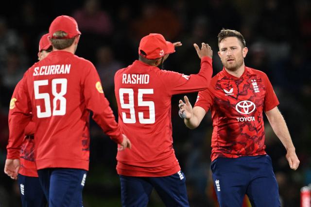 England's Liam Dawson (R) celebrates with teammates after taking the wicket of New Zealand's Mark Chapman during the second Twenty20 international cricket match between New Zealand and England at Hagley Oval in Christchurch on October 20, 2025. (Photo by Sanka VIDANAGAMA / AFP)