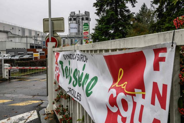 A banner called by French trade union CGT is seen displayed outside the French syrup manufacturer Teisseire, founded in 1971, after the factory announced the closure of its production site in Crolles, near Grenobles, on October 20, 2025. Syrup manufacturer Teisseire, founded in 1971 and currently experiencing financial difficulties, announced on October 16, 2025, the closure of its production site in Crolles (Isère) and a reorganisation plan involving the loss of nearly 170 jobs. (Photo by Jeff PACHOUD / AFP)
