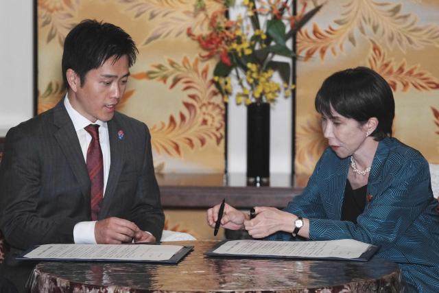 Japan's ruling Liberal Democratic Party (LDP) President Sanae Takaichi (R) and Japan Innovation Party (JIP) leader Hirofumi Yoshimura take part in a signing the policy agreement between the two parties at the Diet in Tokyo on October 20, 2025. Japan's ruling LDP and its junior partner signed a coalition deal on October 20, paving the way for Sanae Takaichi to become the country's first woman premier. (Photo by Kazuhiro NOGI / AFP)