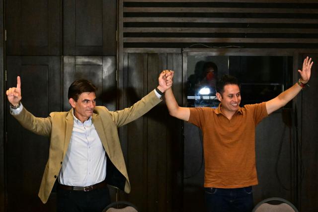 Bolivia's president-and vice-president elect Rodrigo Paz and Edman Lara, of the Christian Democratic Party (PDC), wave during a press conference a day after the presidential election runoff in La Paz, on October 20, 2025. Bolivians on the eve elected pro-business center-right senator Paz as their new president, ending two decades of socialist rule that have left the South American nation deep in economic crisis. (Photo by MARTIN BERNETTI / AFP)