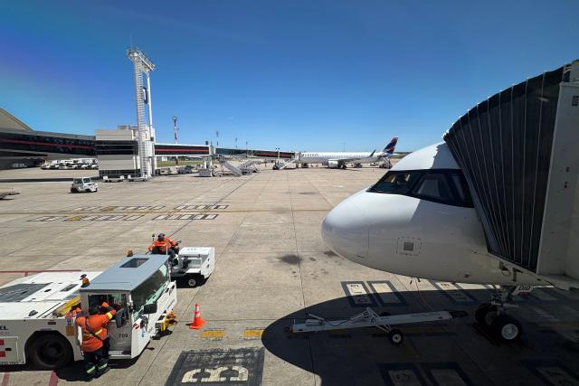 A plane of low-cost carrier JetSmart Airlines (R) sits on the tarmac at Carrasco International Airport in Ciudad de la Costa, close to Montevideo, Uruguay, on October 20, 2025. (Photo by Pablo PORCIUNCULA / AFP)